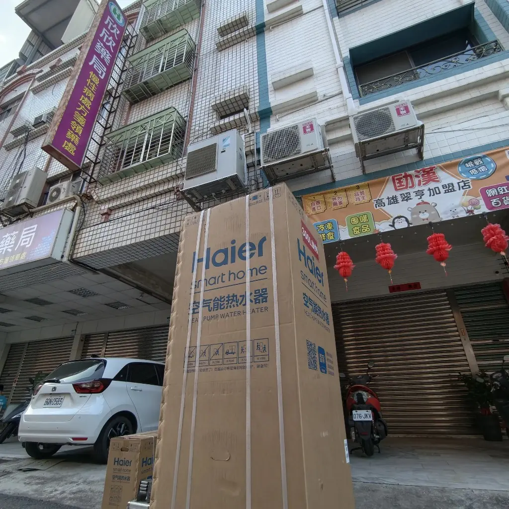 高雄翠亨路商圈街側，海爾SmartHome300L空氣能熱泵熱水器紙箱送達點交，外箱標示HEATPU