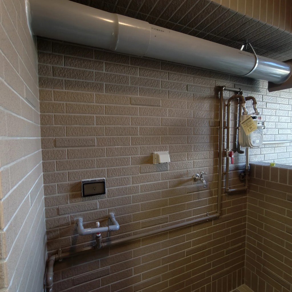 高雄前鎮區英倫亞灣2建案陽台施工前，磚紋牆面預留瓦斯錶與水電接口，尚未安裝海爾DC5強制排氣熱水器